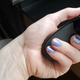 A photo of the author's hand holding a controller. Her nails are a light blue, bordering on lilac.